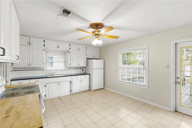 a kitchen with granite countertop a sink cabinets and stainless steel appliances