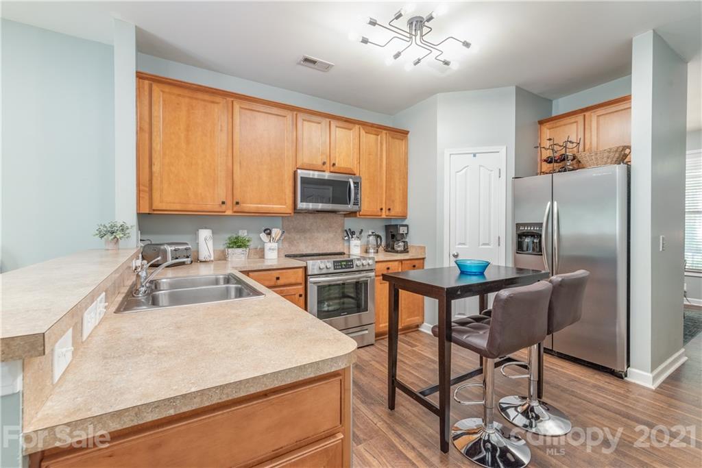 1131 Market Street Fort Mill, SC 29708 - Photo 8 of 27 a kitchen with kitchen island granite countertop a stove a sink a oven with a dining table and chairs