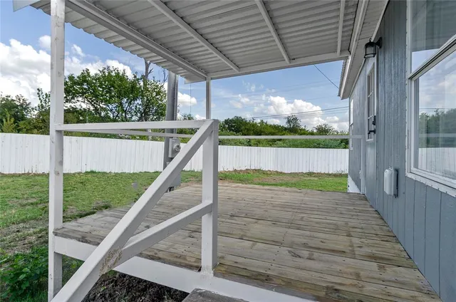 a view of balcony with wooden floor and fence