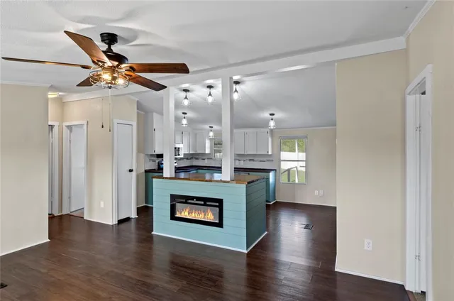 a living room with stainless steel appliances furniture wooden floor and a view of kitchen
