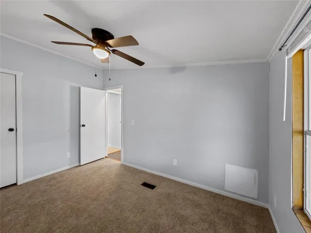 an empty room with a window and a fan