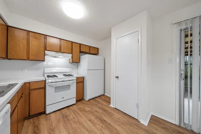 a kitchen with a sink cabinets stainless steel appliances and wooden floor