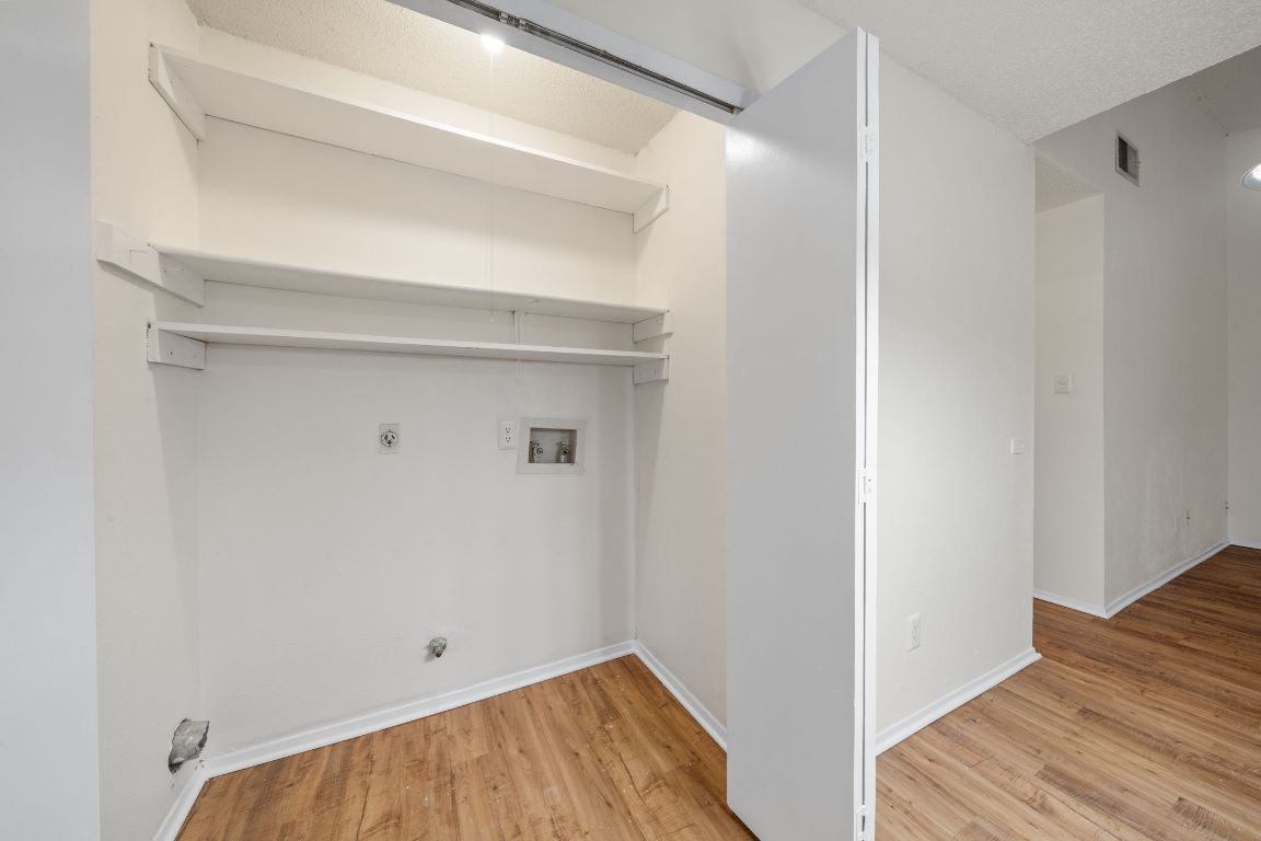 100 Meteor Drive, Unit B Austin, TX 78745 - Photo 13 of 29 Washroom with light wood-style flooring, washer hookup, gas dryer hookup, hookup for an electric dryer, and a textured ceiling