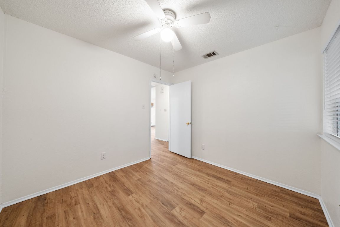 100 Meteor Drive, Unit B Austin, TX 78745 - Photo 21 of 29 Spare room featuring light wood finished floors, a textured ceiling, and a ceiling fan