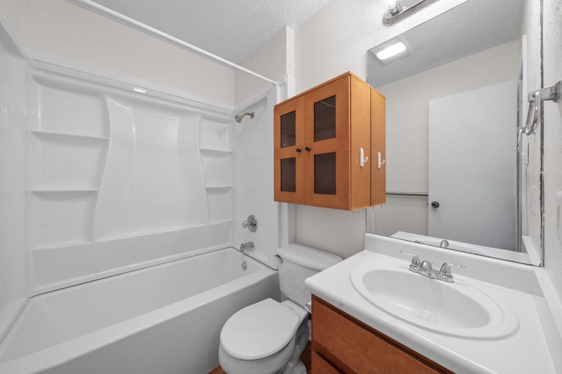 100 Meteor Drive, Unit B Austin, TX 78745 - Photo 23 of 29 Full bathroom featuring shower / tub combination, vanity, and a textured ceiling