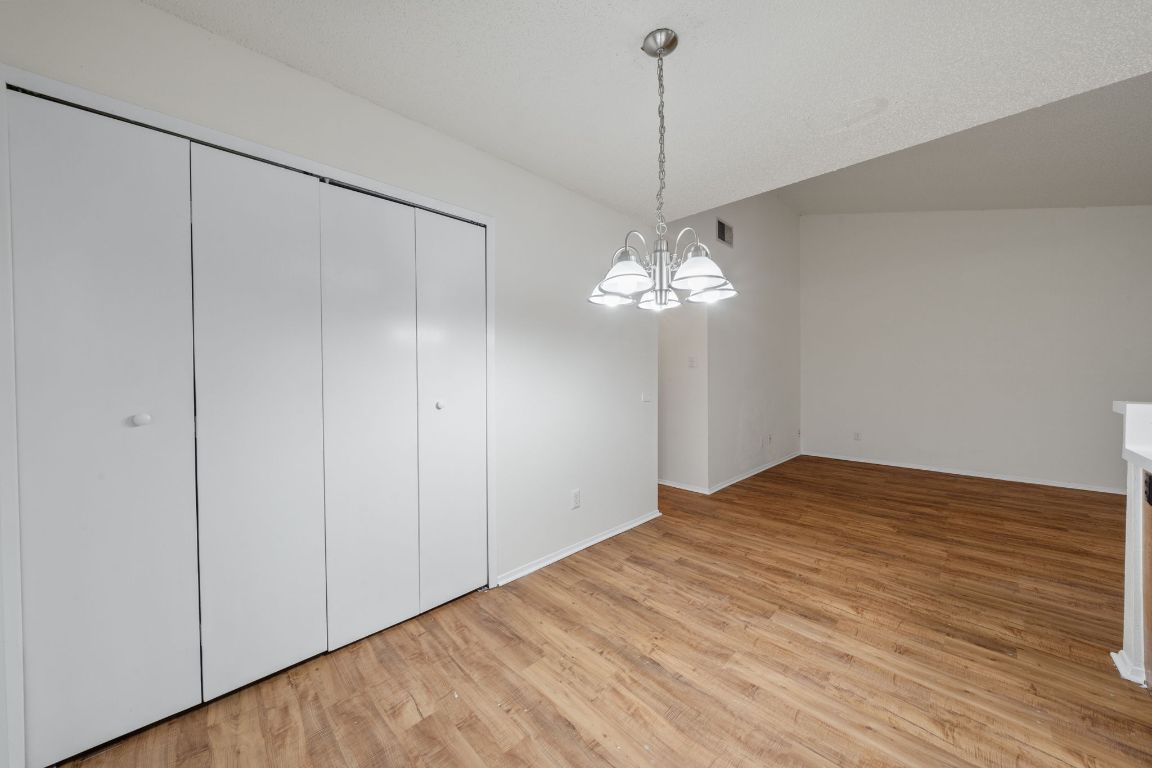 100 Meteor Drive, Unit B Austin, TX 78745 - Photo 8 of 29 Unfurnished dining area featuring light wood-style flooring and a chandelier