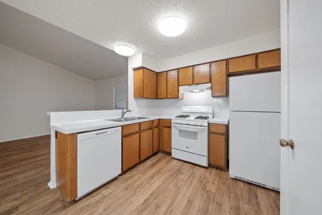 a kitchen with stainless steel appliances granite countertop a sink cabinets a refrigerator and a stove