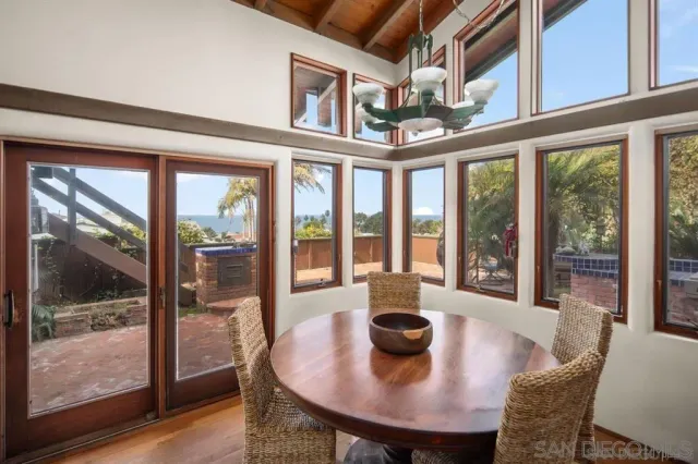 a view of a dining room with furniture large windows and wooden floor