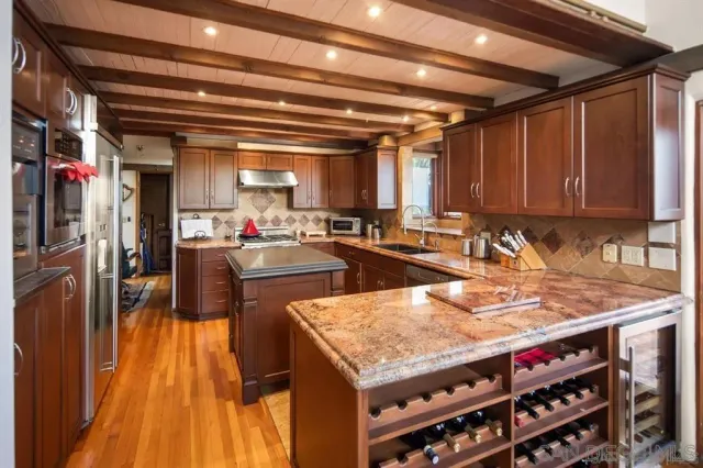 a kitchen with stainless steel appliances granite countertop a sink stove and cabinets