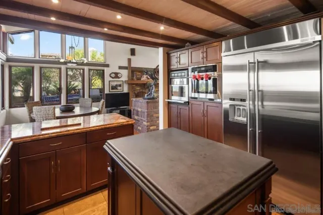 a kitchen with a refrigerator a sink and wooden cabinets