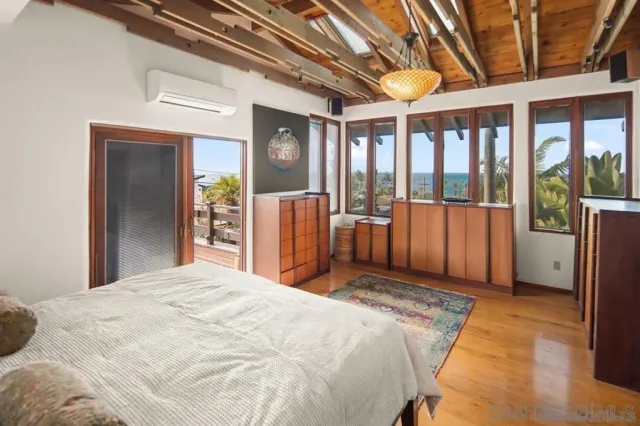 a bedroom with a bed and a large window with balcony view