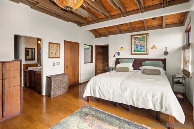 a bedroom with bed and wooden floor