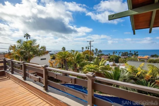 a view of a balcony with wooden chairs
