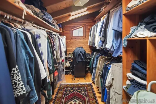 a view of walk in closet with clothes and shoes