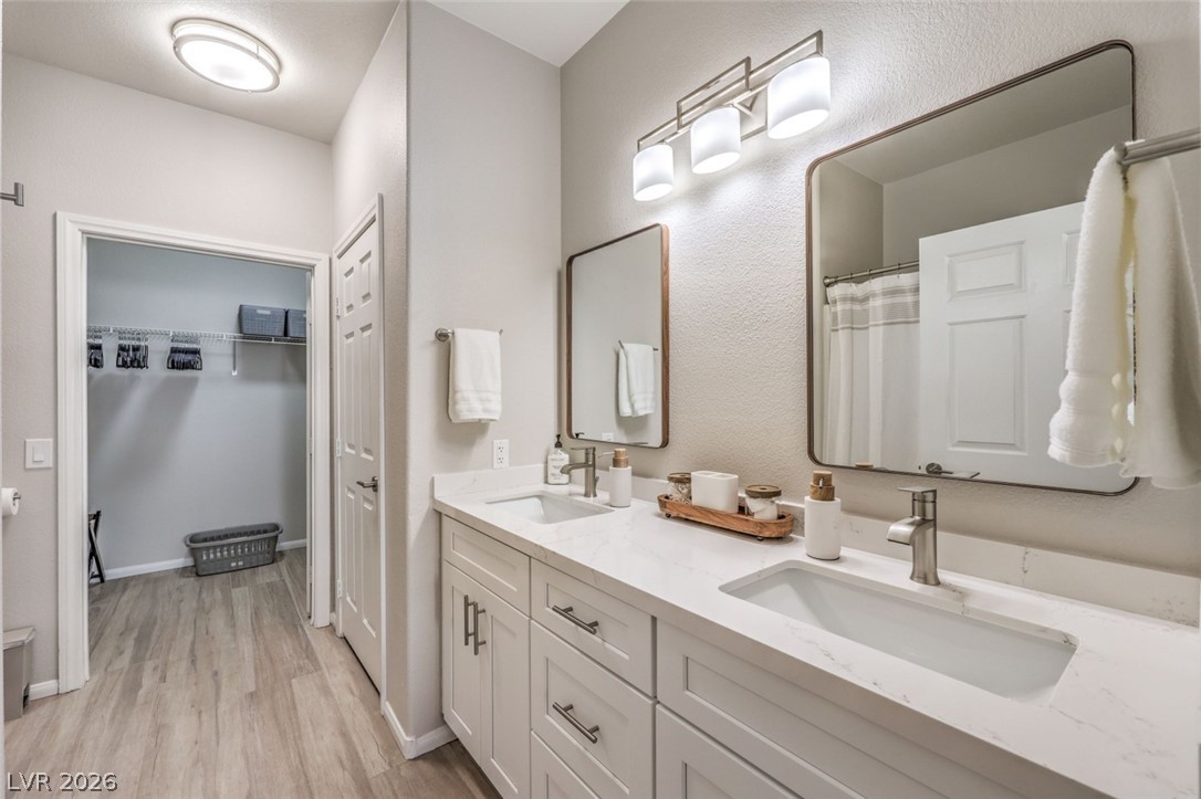 855 North Stephanie Street, Unit 1015 Henderson, NV 89014 - Photo 17 of 27 Primary bath featuring dual sinks, quartz counters, white shaker w/soft close drawers, linen closet & tub/shower combo.