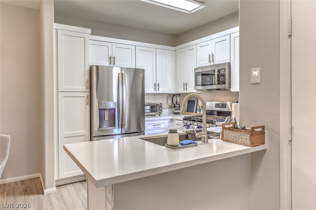 855 North Stephanie Street, Unit 1015 Henderson, NV 89014 - Photo 6 of 27 Kitchen boasts breakfast bar w/quaetz counters, white shaker cabinets w/soft close drawers & doors, stainless steel appliances, dining nook & pantry.
