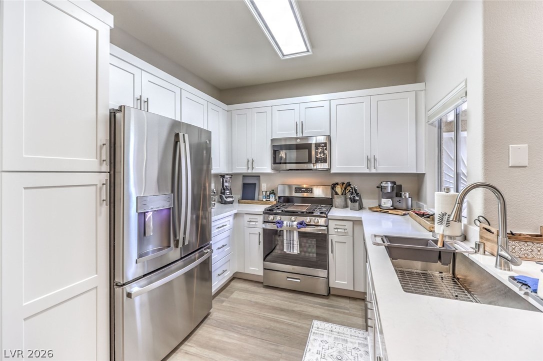 855 North Stephanie Street, Unit 1015 Henderson, NV 89014 - Photo 7 of 27 Kitchen boasts breakfast bar w/quaetz counters, white shaker cabinets w/soft close drawers & doors, stainless steel appliances, dining nook & pantry.