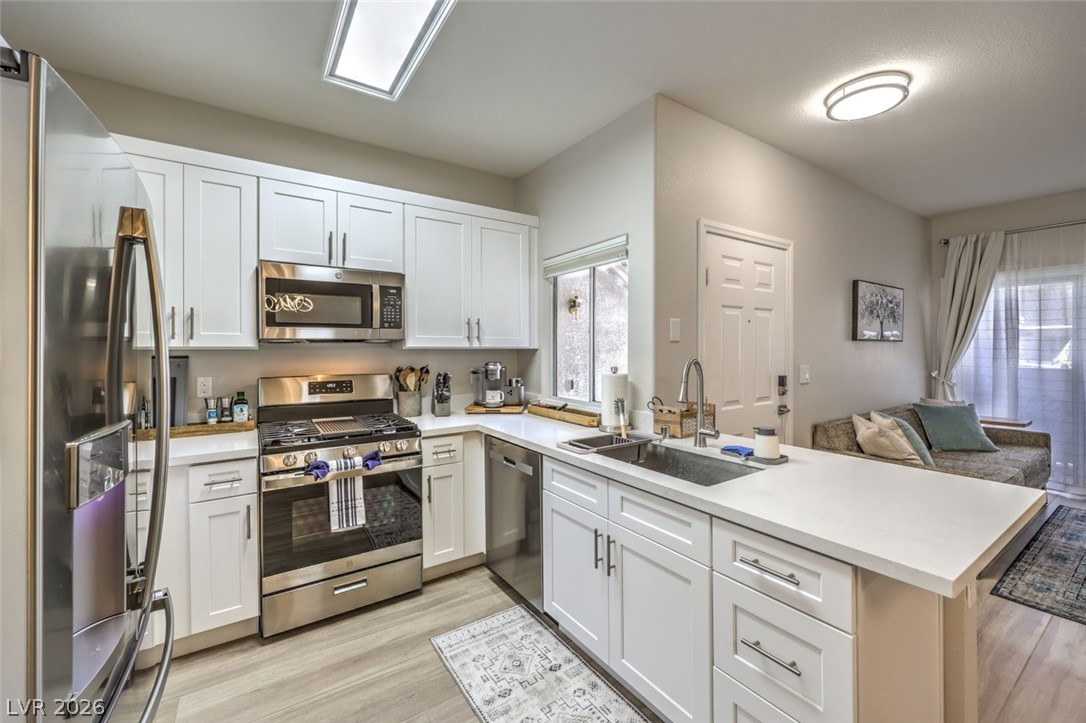 855 North Stephanie Street, Unit 1015 Henderson, NV 89014 - Photo 8 of 27 Kitchen boasts breakfast bar w/quaetz counters, white shaker cabinets w/soft close drawers & doors, stainless steel appliances, dining nook & pantry.