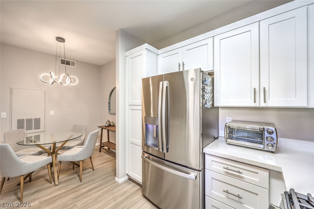 855 North Stephanie Street, Unit 1015 Henderson, NV 89014 - Photo 10 of 27 Kitchen boasts breakfast bar w/quaetz counters, white shaker cabinets w/soft close drawers & doors, stainless steel appliances, dining nook & pantry.