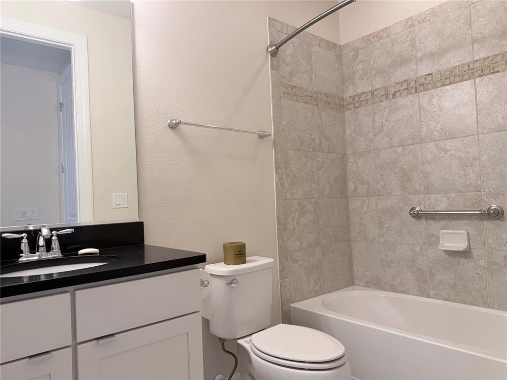 10041 Southwest 77th Loop Ocala, FL 34481 - Photo 14 of 39 a bathroom with a bathtub shower sink vanity and toilet