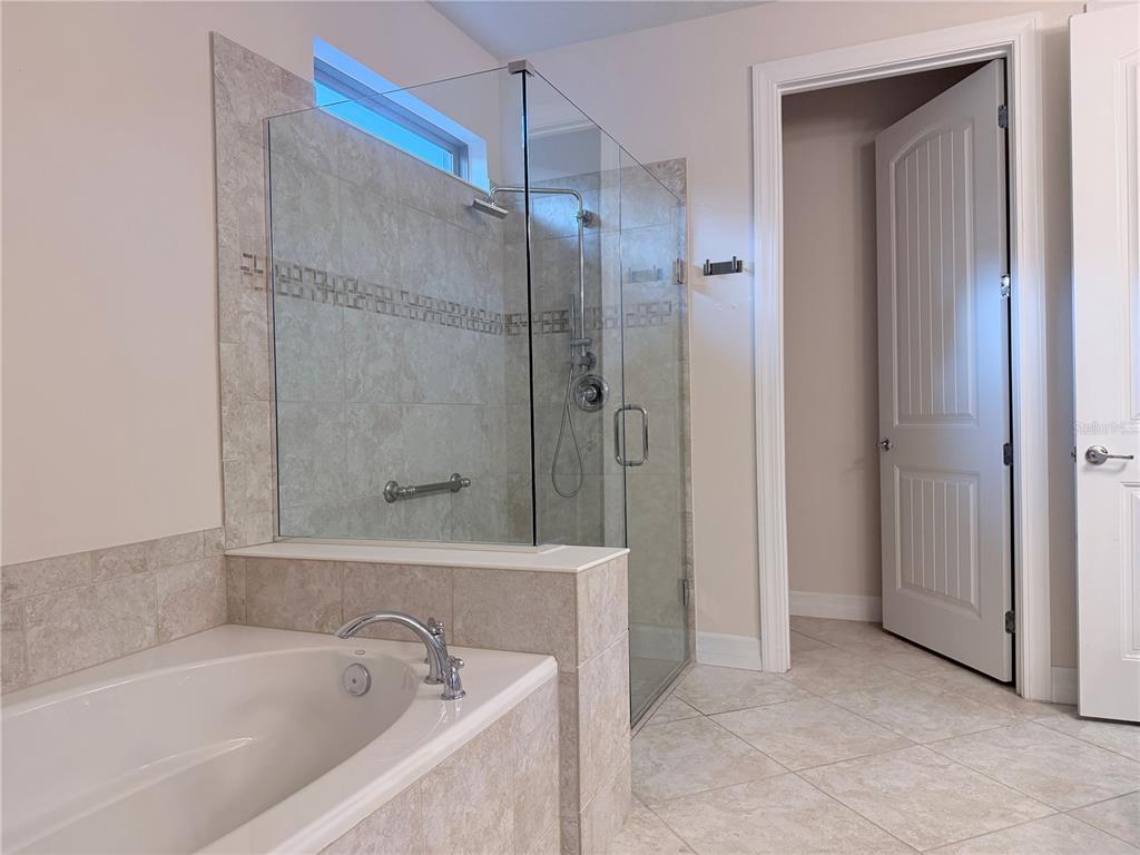 10041 Southwest 77th Loop Ocala, FL 34481 - Photo 19 of 39 a bathroom with a bathtub and a shower