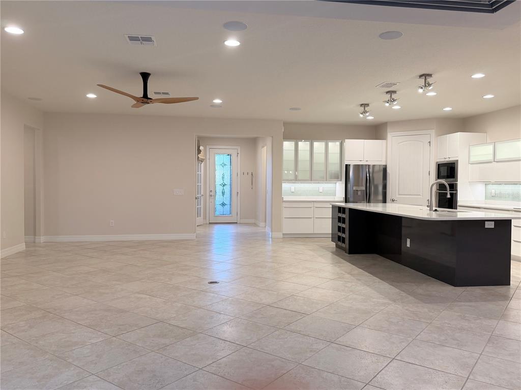 10041 Southwest 77th Loop Ocala, FL 34481 - Photo 2 of 39 a large kitchen with stainless steel appliances a large counter top a refrigerator and a sink