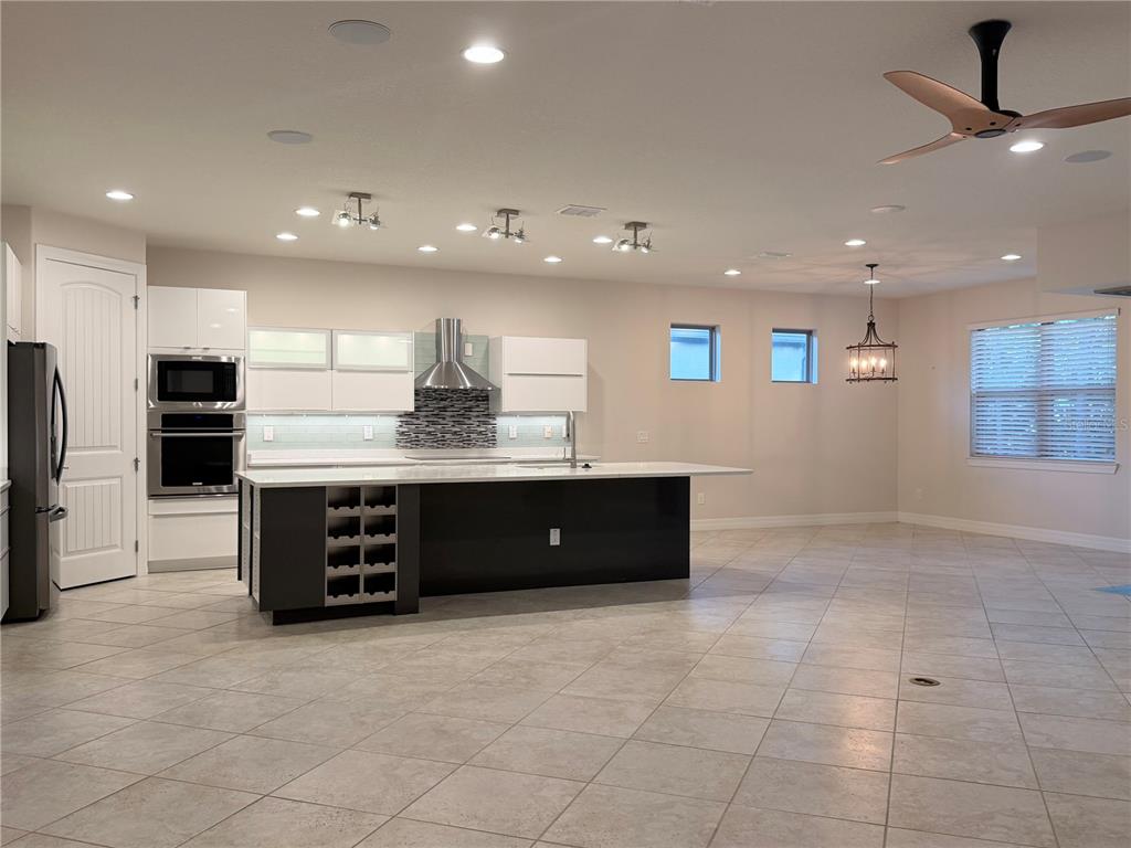10041 Southwest 77th Loop Ocala, FL 34481 - Photo 6 of 39 a large kitchen with stainless steel appliances granite countertop a large counter top a stove a sink and a refrigerator