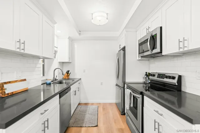 a kitchen with stainless steel appliances a sink stove top oven and cabinets
