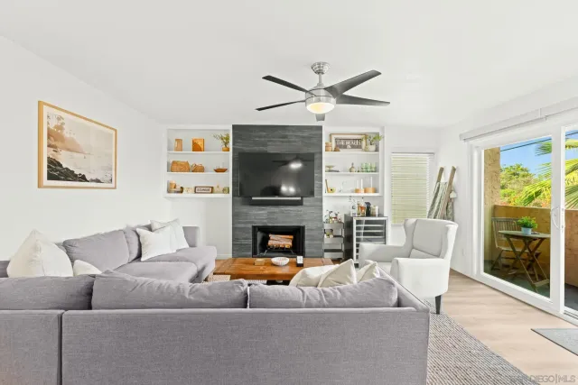 a living room with furniture a fireplace and a large window