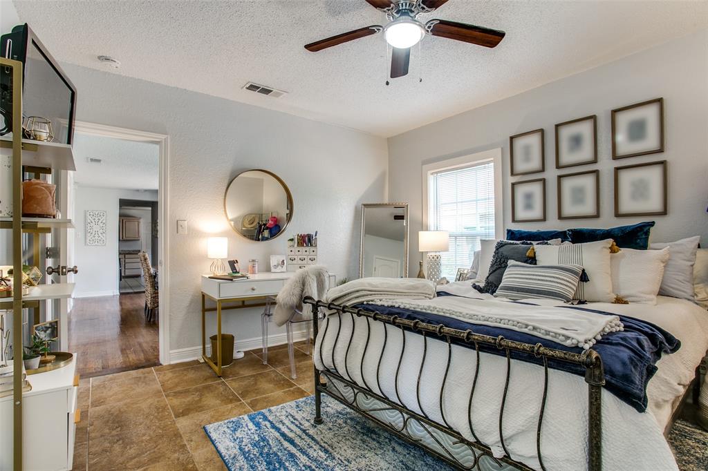 3005 6th Avenue Fort Worth, TX 76110 - Photo 15 of 18 a bedroom with a bed and a chandelier