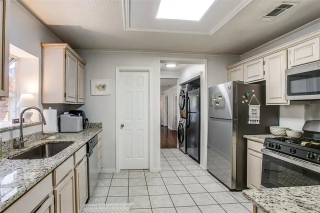a kitchen with stainless steel appliances granite countertop a sink stove and refrigerator