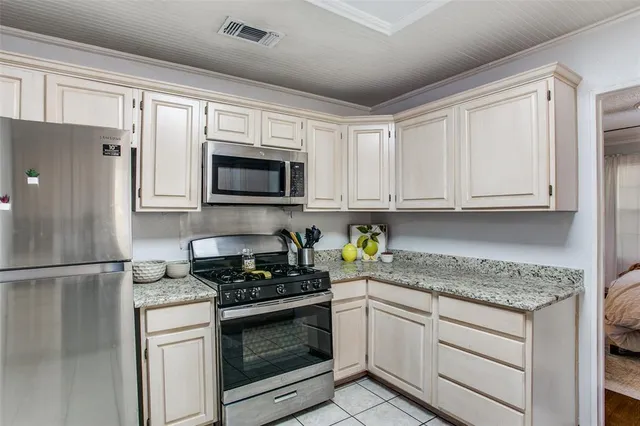 a kitchen with granite countertop white cabinets stainless steel appliances and a sink