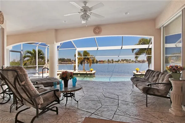 a living room with patio furniture and a floor to ceiling window