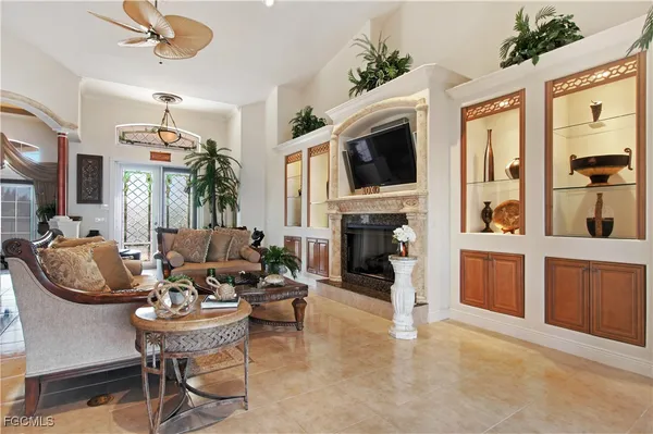 a living room with furniture a fireplace and a chandelier