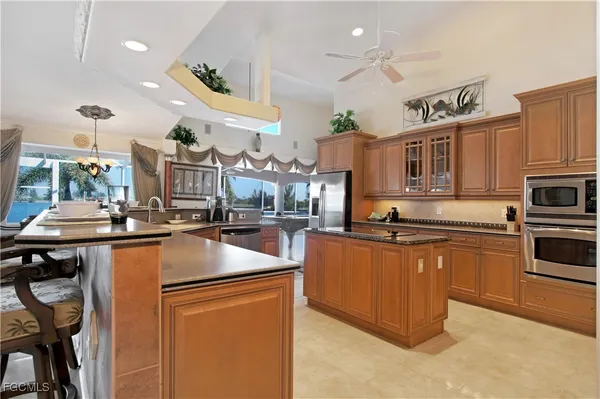 a kitchen with stainless steel appliances granite countertop a sink a stove and a refrigerator
