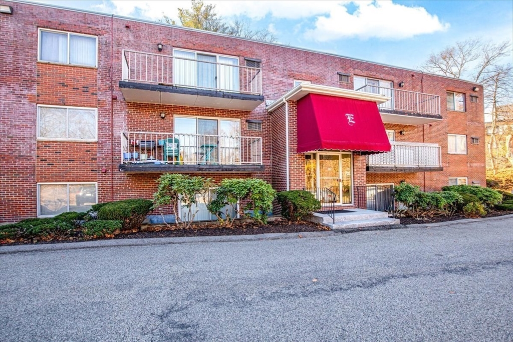 a view of a building with a yard and plants