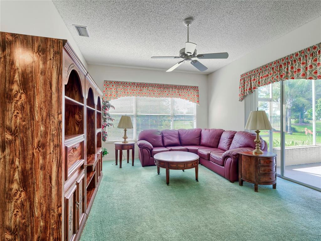 11228 Windrush Circle Hudson, FL 34667 - Photo 6 of 67 a living room with furniture and a floor to ceiling window
