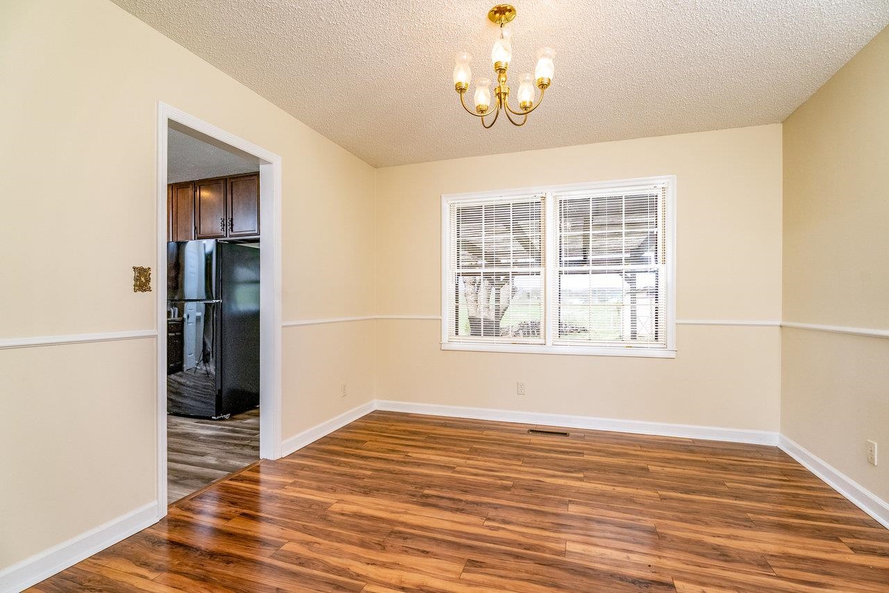 456 Eckert Circle Harrisonburg, VA 22801 - Photo 10 of 48 an empty room with wooden floor chandelier and windows