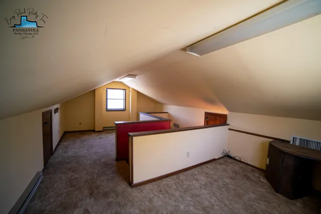 a view of a livingroom with wooden furniture and windows