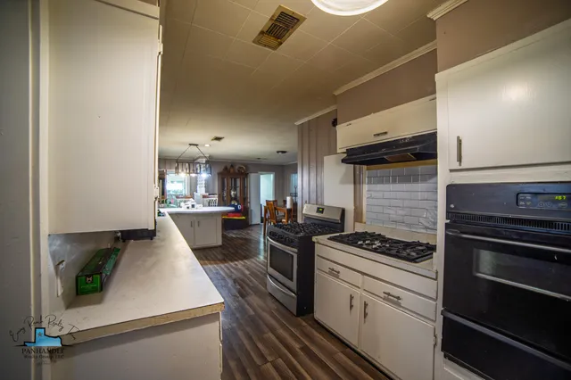 a kitchen with stove and cabinets