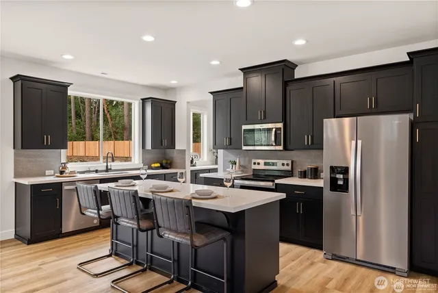 a kitchen with kitchen island granite countertop a sink stove and refrigerator