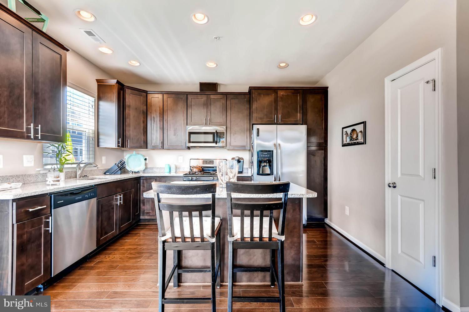 2033 Case Road Baltimore, MD 21222 - Photo 10 of 30 a kitchen with stainless steel appliances granite countertop a refrigerator a sink dishwasher a dining table and chairs with wooden floor