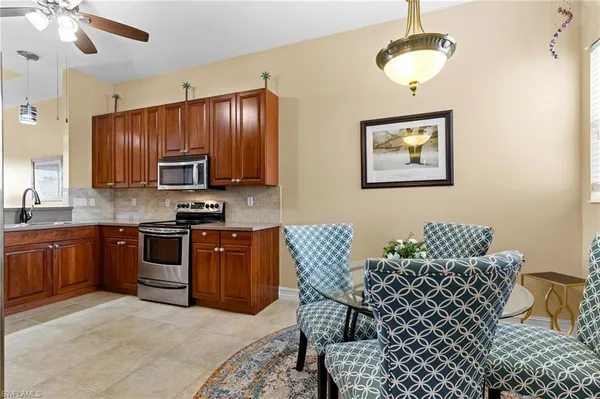 a kitchen with stainless steel appliances granite countertop a stove a sink dishwasher a microwave oven with a dining table and chairs