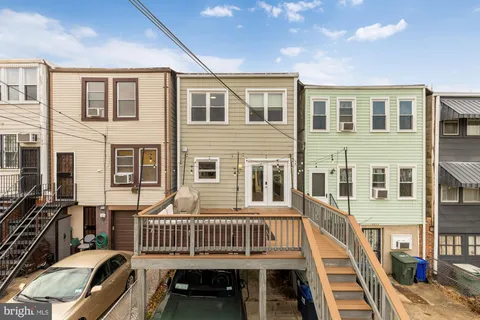 a view of a house with a large window and wooden deck