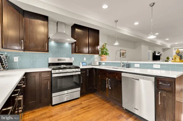 a kitchen with stainless steel appliances granite countertop a stove a sink and a microwave