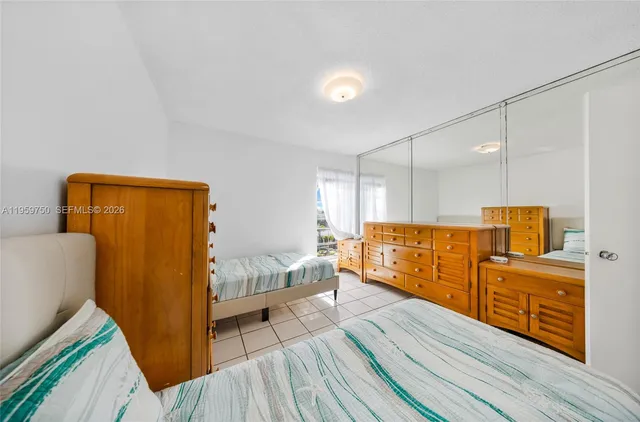 a spacious bedroom with a bed and wooden floor