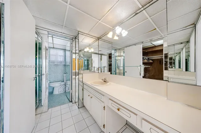 a large white bathroom with a sink and mirror