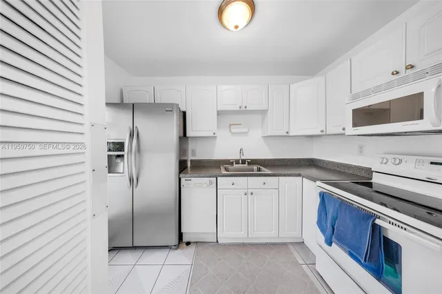 a kitchen with stainless steel appliances granite countertop a refrigerator sink and stove