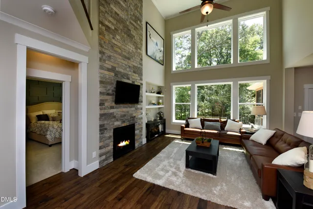 a living room with fireplace furniture and a large window