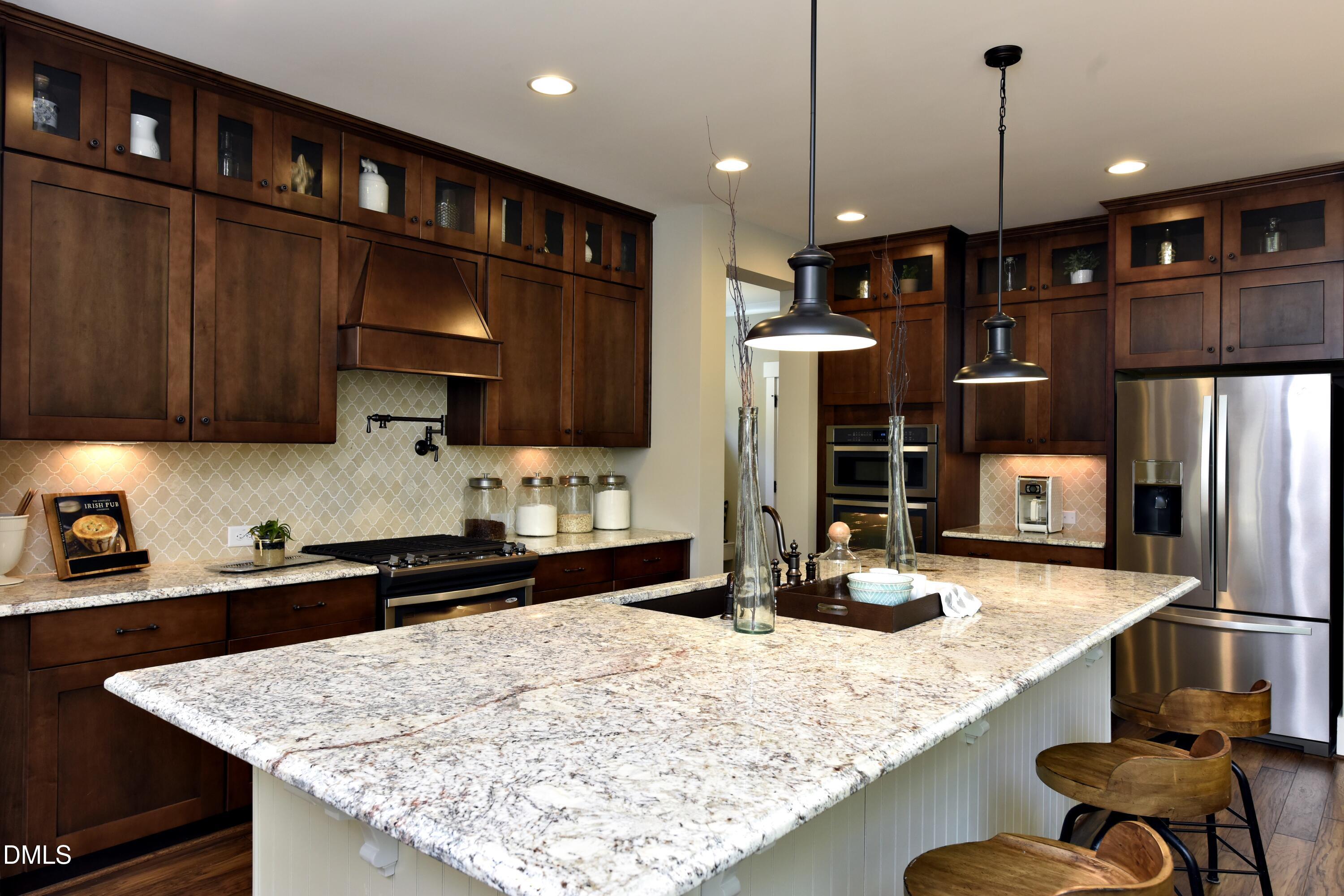 4 Wolf Tree Way Efland, NC 27243 - Photo 4 of 28 a kitchen with granite countertop a stove refrigerator and cabinets